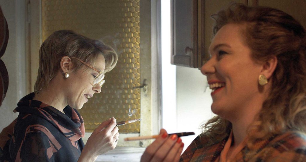 Marijana (Dubravka Kovjanic) smoking and laughing with her friend Ceca (Jelena Djokic). 