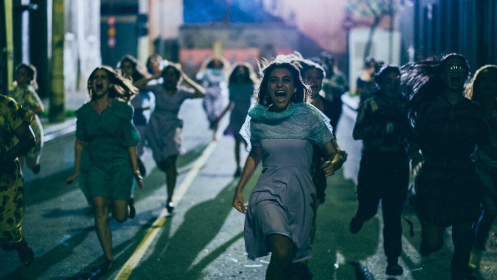 A group of women running through the street, screaming.