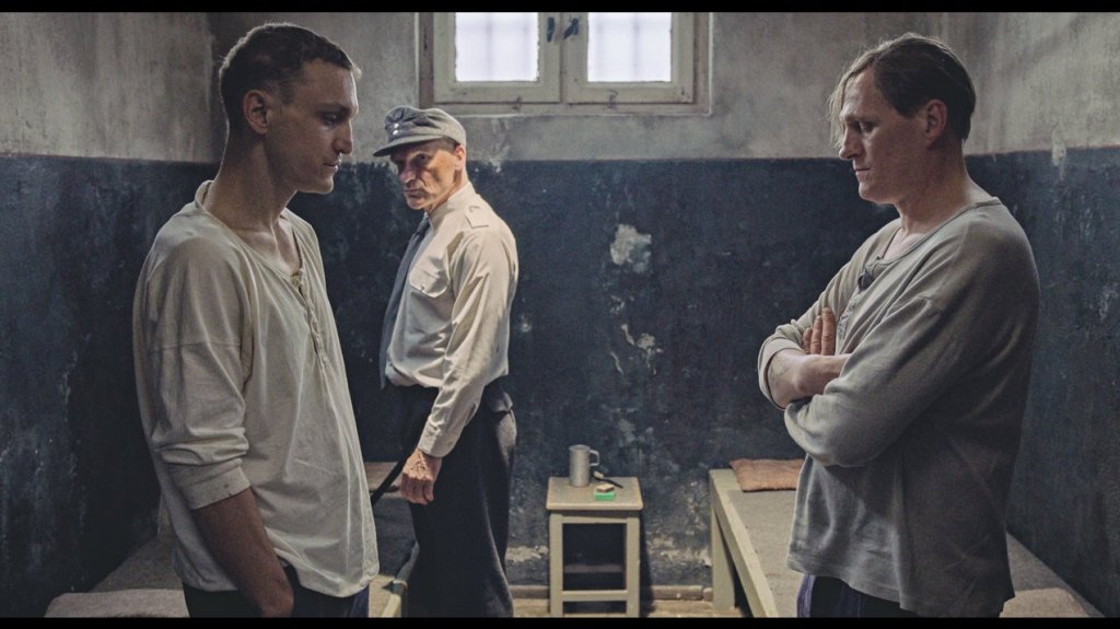Hans (Franz Rogowski) and Viktor (Georg Friedrich) facing each other as their cell is inspected.