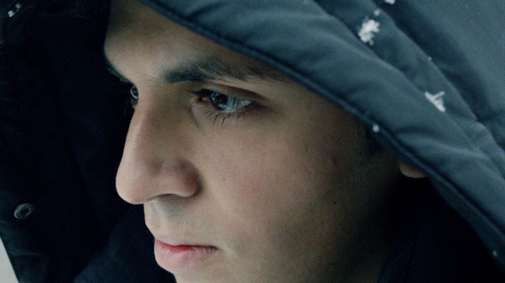 Close-up of a teenage boy in a hooded jacket.