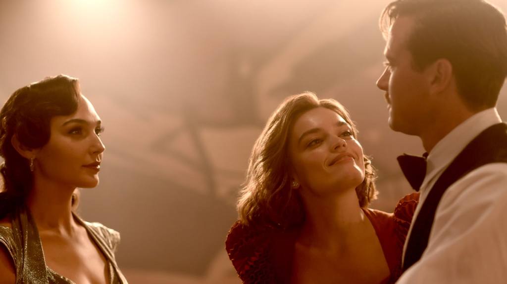 Linnet (Gal Gadot) and Simon (Armie Hammer) staring at each other while Jacqueline (Emma Mackey) smiles at Simon.