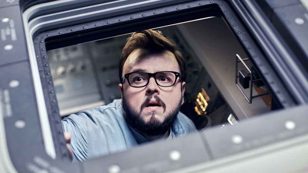 KC Houseman (John Bradley) looking out the window of a space shuttle.