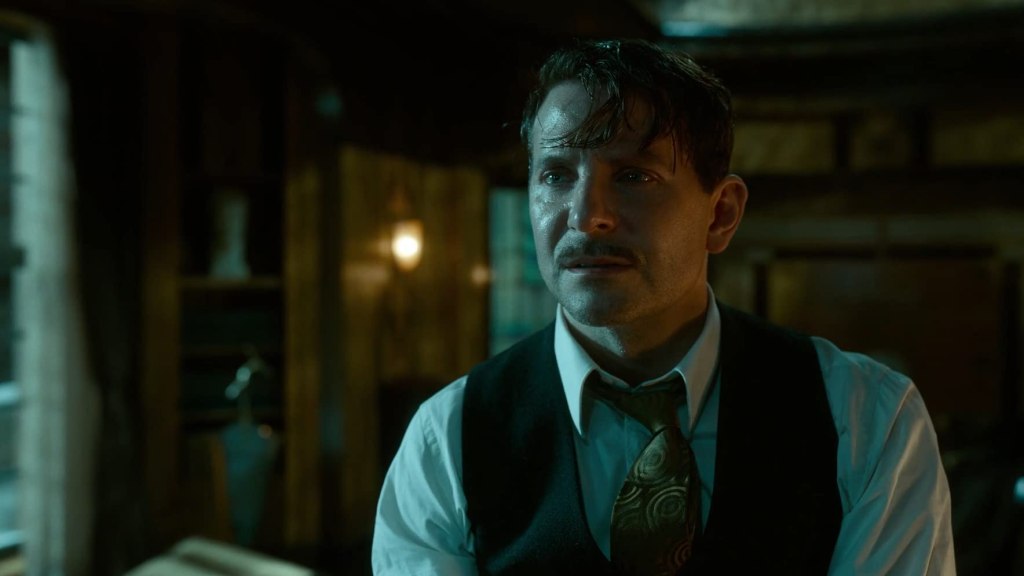 Stanton (Bradley Cooper) sitting disheveled in a dark room.