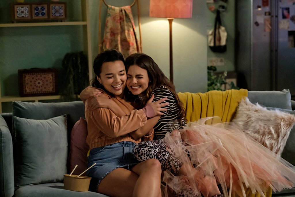Cassie (Victoria Justice) and Lisa (Midori Francis) hugging on the couch.