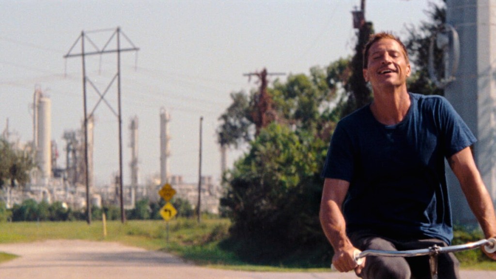 Mikey (Simon Rex) riding a bike, looking blissful. 