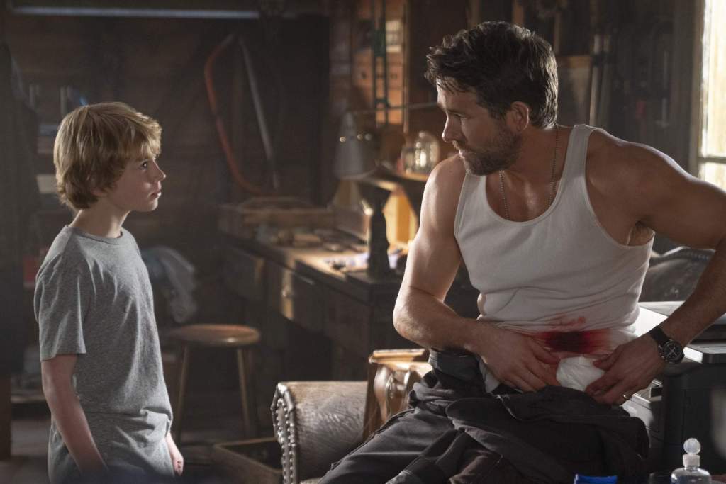 Young Adam (Walker Scobell) watches Older Adam (Ryan Reynolds) treat his wound.