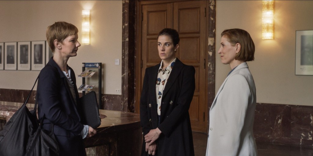 Clara (Anne Schäfer) introducing Hanna (Sandra Hüller) to her professor Margot (Judith Hofmann).