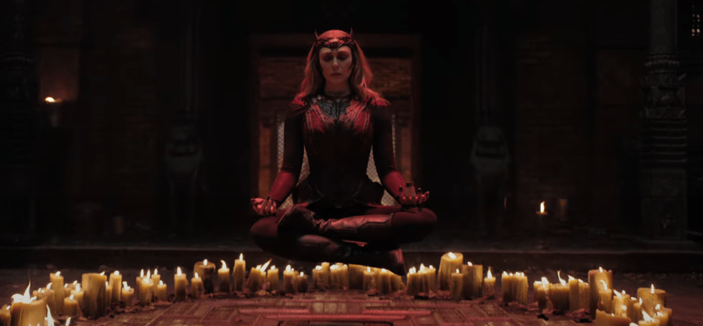 Wanda (Elizabeth Olsen) levitating in the lotus position over a circle of candles.