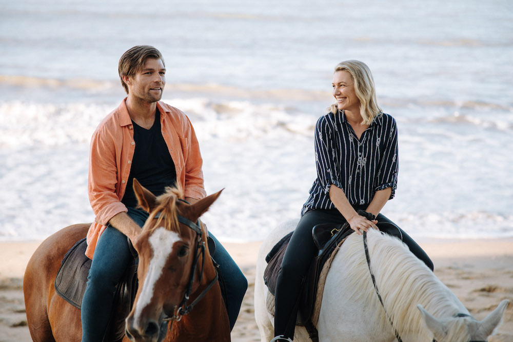 Chip (Liam McIntyre) and Laura (Saskia Hampele) horsebackriding on the beach.