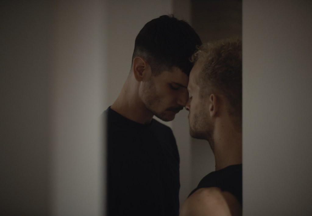 The Psychologist (Mickaël Pelissier) and his client (Casper Wubbolts) standing close together, almost kissing.