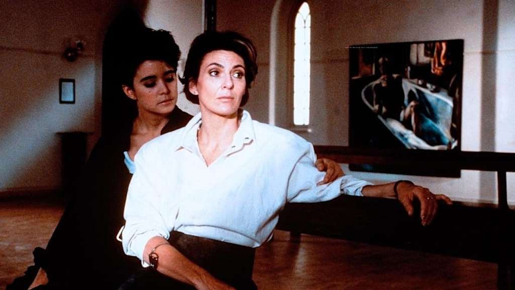 Mary (Ann-Marie MacDonald) and Gabrielle (Paule Baillargeon) sitting close in Gabrielle's gallery.