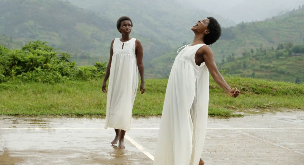Modesta (Belinda Rubango) and Gloriosa (Albina Kirenga) standing in the rain.