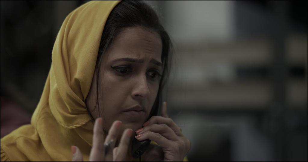 Aliah (Rucha Inamdar) on the phone, looking worried.