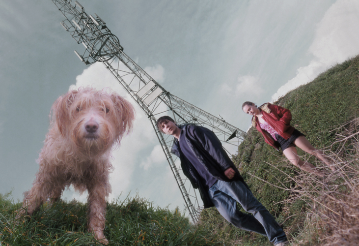 The dog, the boy (Freddie Cunliffe) and the girl (Joanne Hill) in front of an electrical tower. The image angle of the dog doesn't fit the rest of the image.