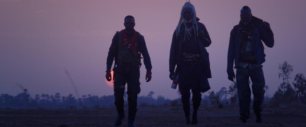 Chaka (Yann Gael), Minuit (Mentor Ba) and Rafa (Roger Sallah) silhouetted against the setting sun. 