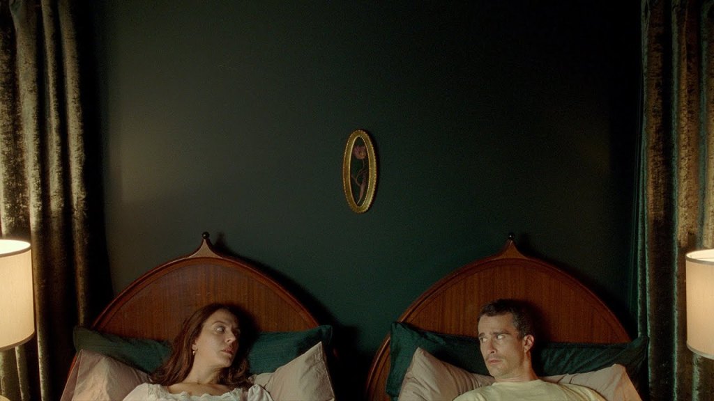 Nadine (Monia Chokri) and Cédric (Patrick Hivon) lying in their bed, looking at each other.