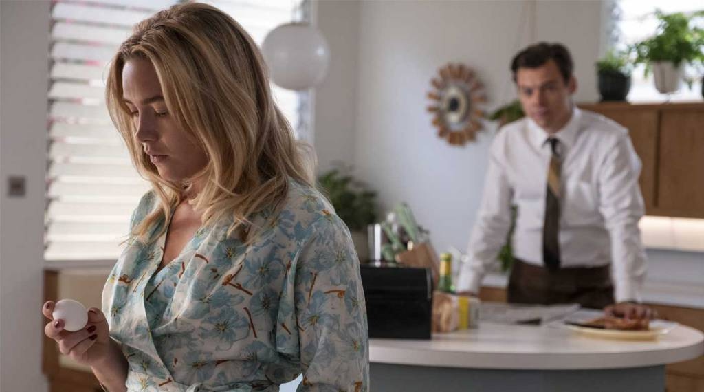 Alice (Florence Pugh) looking doubtfully at an egg. Jack (Harry Styles) is standing behind her.