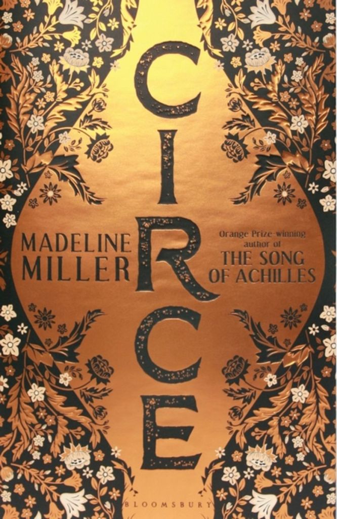The book cover covered in gold, black and white flowers.