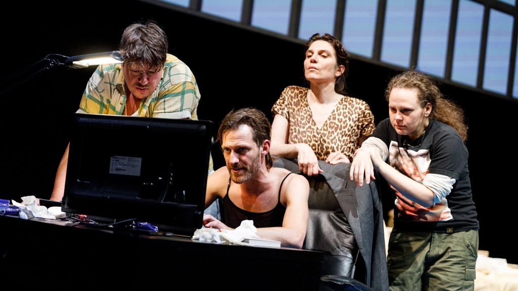 The four Preciados of the play (Thomas Frank, Christoph Rothenbuchner, Birgit Stöger, Bettina Schwarz) in front of a computer monitor. 