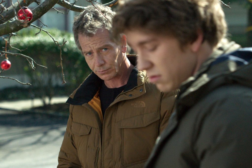 Anders (Ben Mendelsohn) hanging up Christmas decorations with his son Preston (Thomas Mann).
