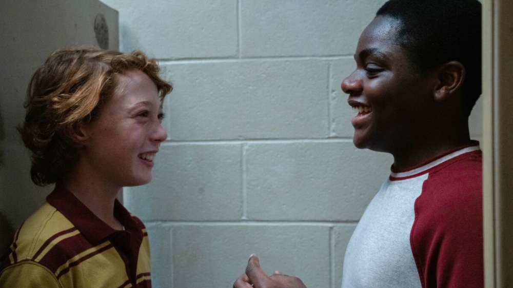 Paul (Banks Repeta) and Johnny (Jaylin Webb) laughing in a bathroom stall together.