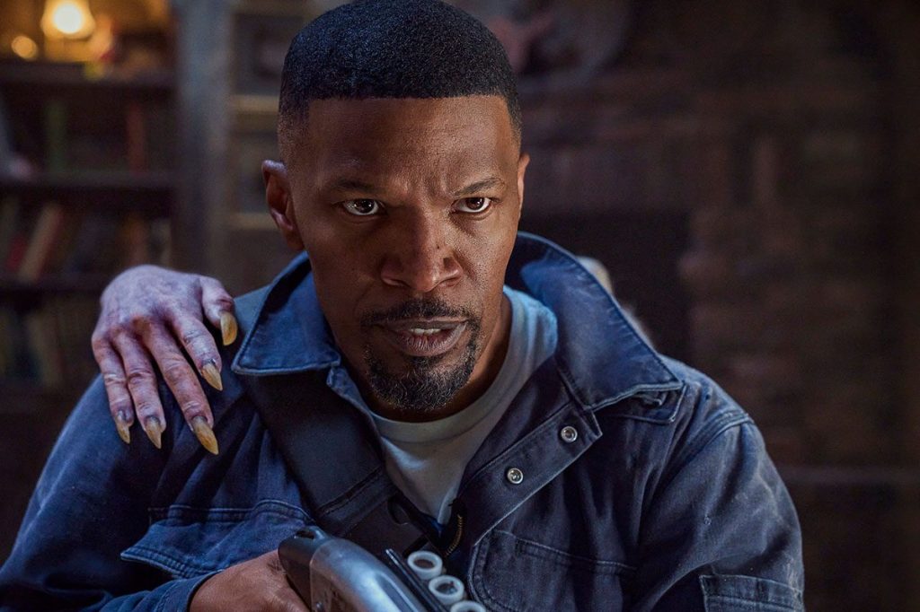 Bud (Jamie Foxx) with a dead-looking hand with very long fingernails on his shoulder.
