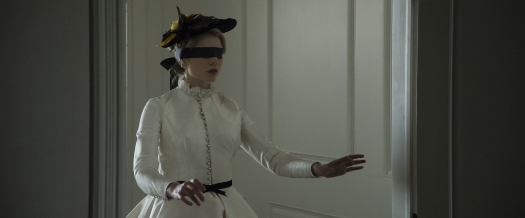 Polly (Lucy Boynton) walking through the house in a blindfold. 