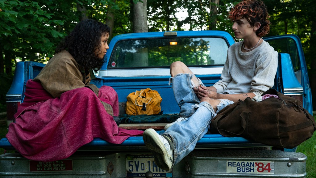 Maren (Taylor Russell) and Lee (Timothée Chalamet) sitting in the bed of a truck together.