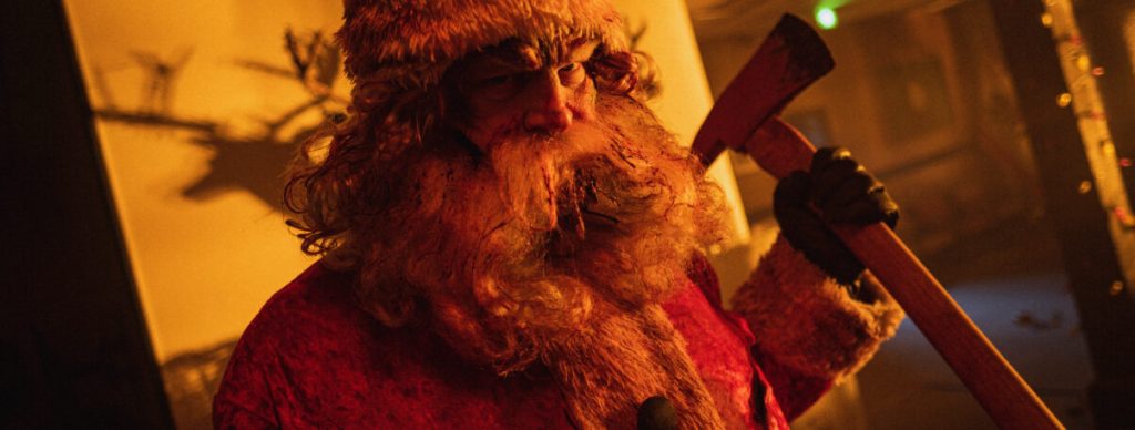 Santa (Abraham Benrubi) preparing to attack with an axe.