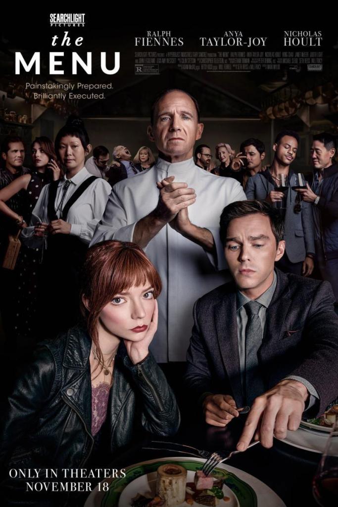 The film poster showing Margot (Anya Taylor-Joy) and Tyler (Nicholas Hoult) at a table, Chef Slowik (Ralph Fiennes) behind them, his hands in a clap. Behind him are the rest of the guests and his maitre d' Elsa (Hong Chau).