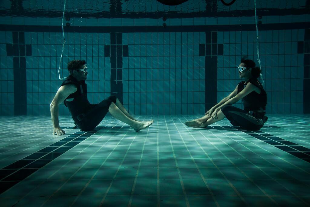 Rick (Sam Worthington) and Tally (Nathalie Emmanuel) working on their diving in a pool.