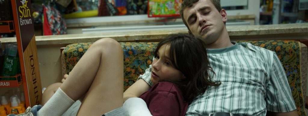 Calum (Paul Mescal) and Sophie (Frankie Corio) huddled together in an armchair.