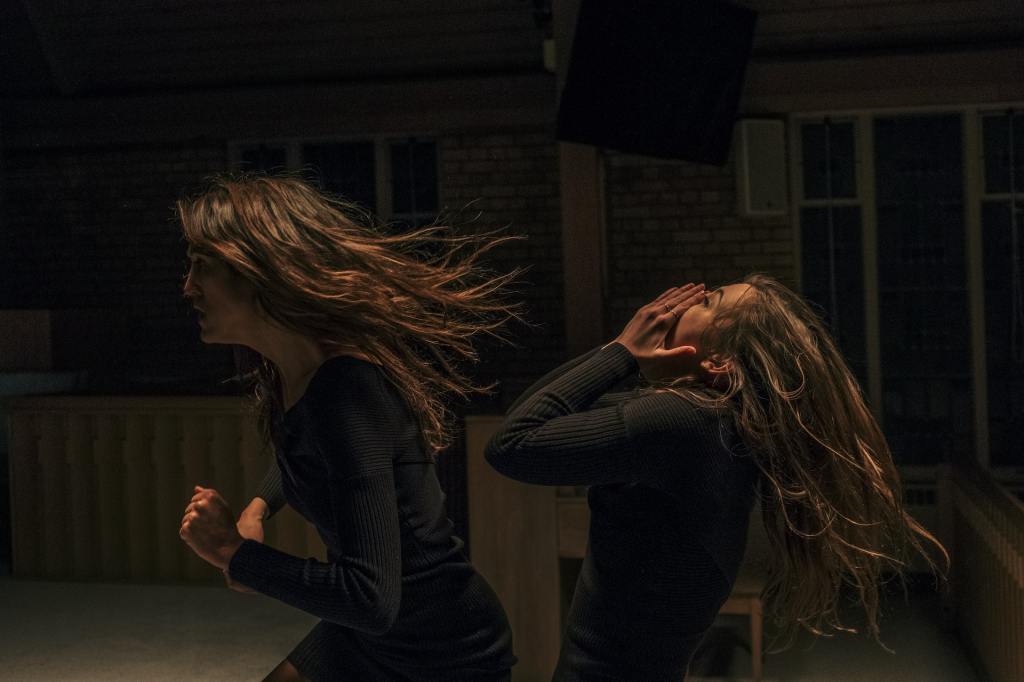 Cassandra (Amy Nostbakken) and Cassandra (Norah Sadava) walking through the night. The former is running, the latter seems to be screaming.