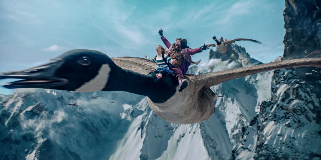 Nemo (Marlow Barkley) and Flip (Jason Momoa) flying on a giant goose.