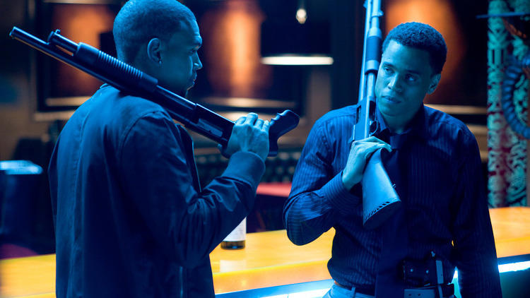 Brothers Jesse (Chris Brown) and Jake (Michael Ealy) looking at each other, shotguns leaning over their shoulders.