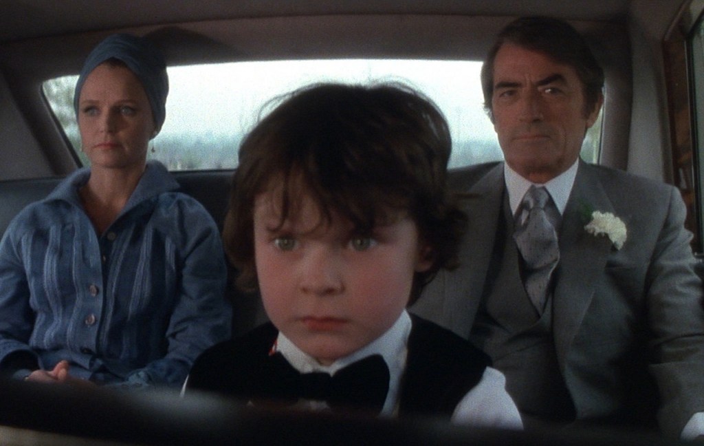 Katherine (Lee Remick) and Robert (Gregory Peck) in the car with Damien (Harvey Stephens).