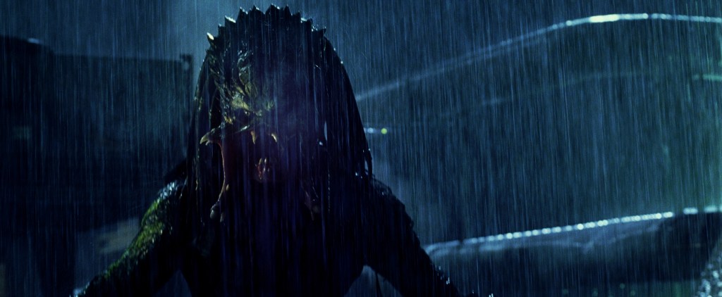 A Predator standing in the rain, face visible.