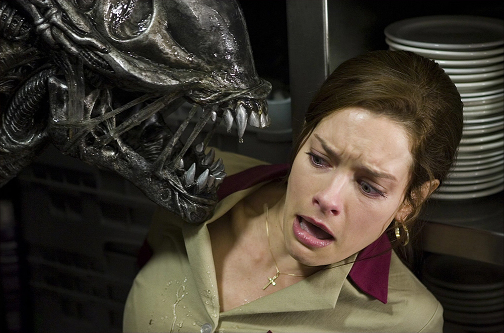 An Alien getting into a woman's (Gina Holden) face. 
