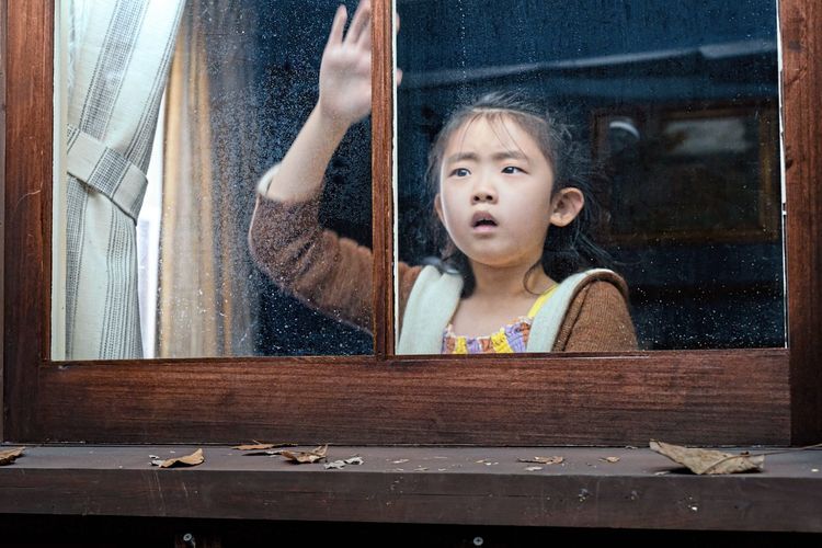 Wen (Kristen Cui) banging her flat hand against a window.