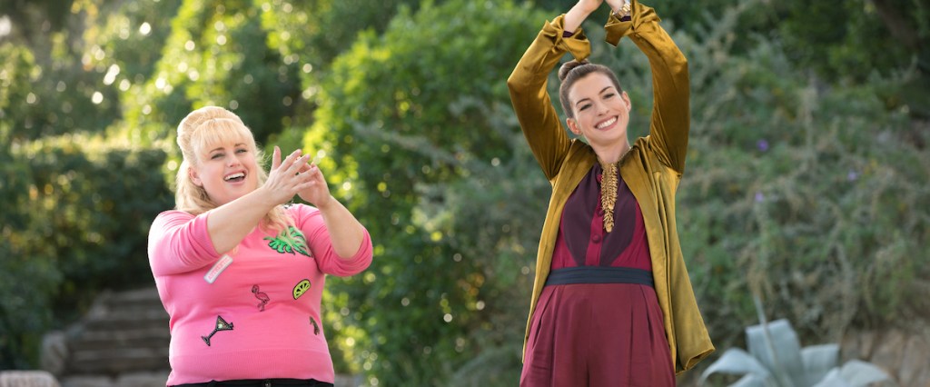 Penny (Rebel Wilson) and Josephine (Anne Hathaway) clapping enthusiastically.