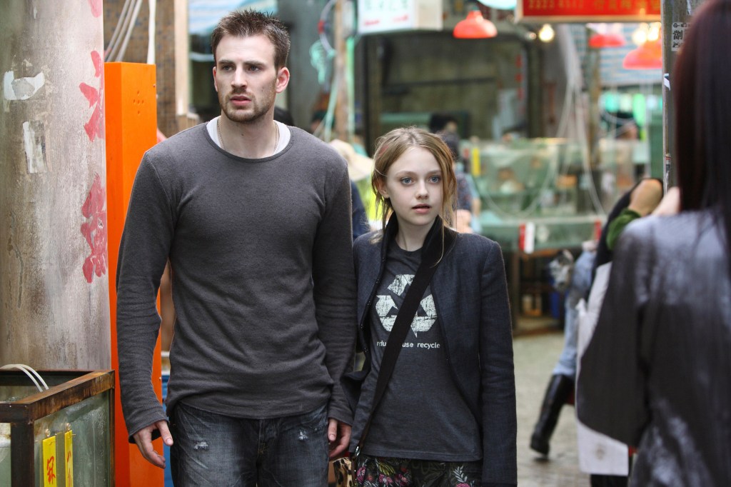Nick (Chris Evans) and Cassie (dakota Faning) standing in a Hong Kong market, looking threatened.