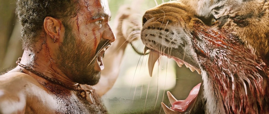 Bheem (N.T. Rama Rao Jr.) facing a tiger, both snarling.