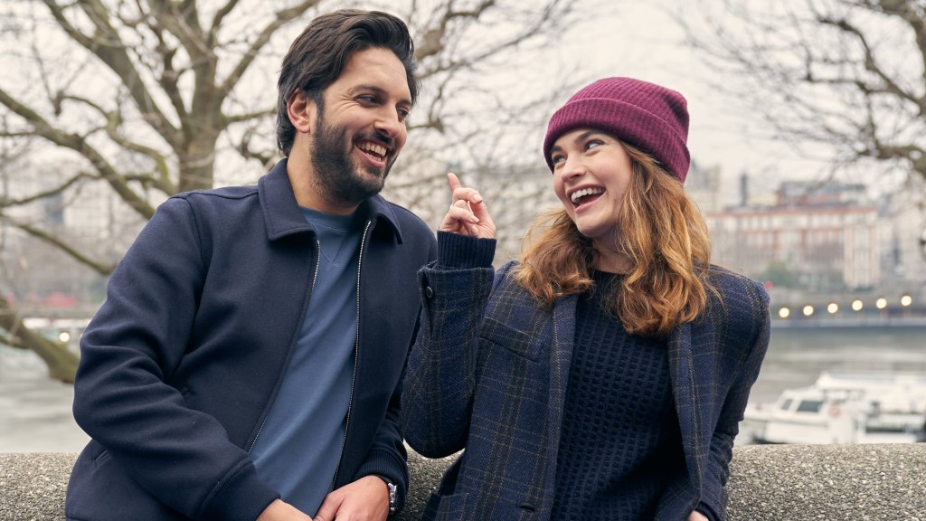 Kazim (Shazad Latif) and Zoe (Lily James) laughing with each other.
