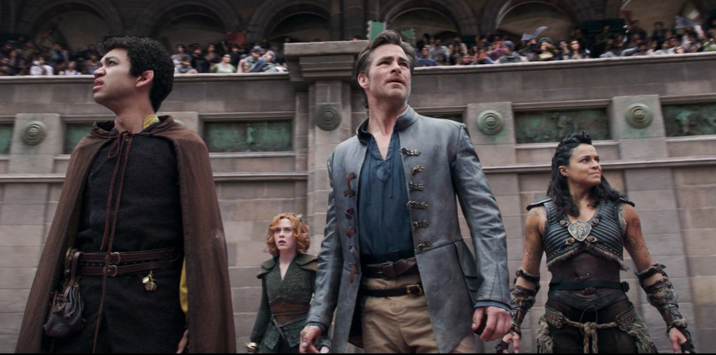 Simon (Justice Smith), Doric (Sophia Lillis), Edgin (Chris Pine) and Holga (Michelle Rodriguez) in an arena, looking worriedly at the audience.