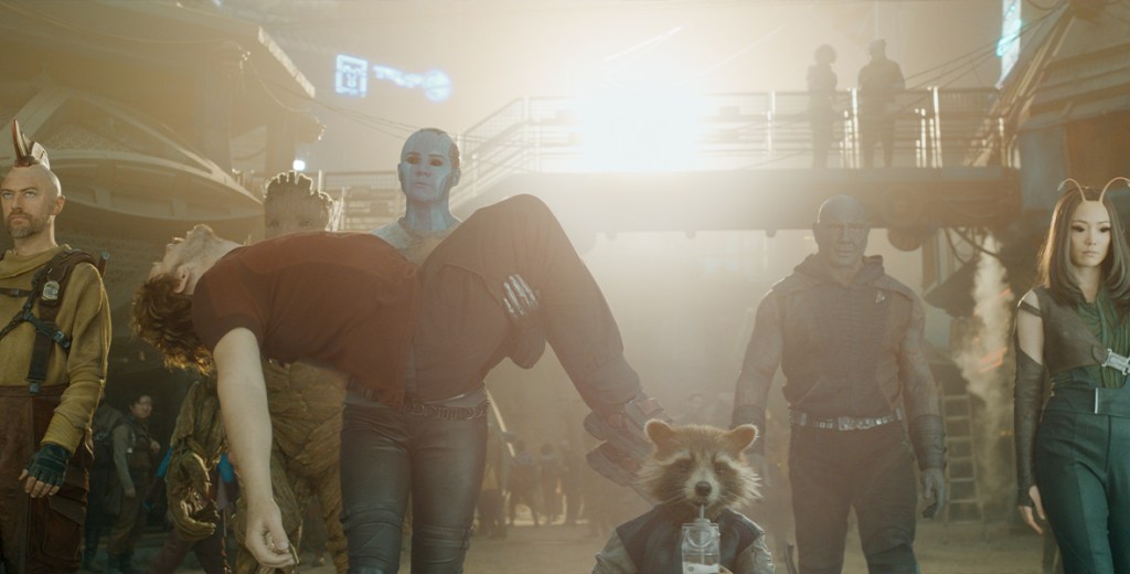 The Guardians walking together with Nebula (Karen Gillam) carrying Peter (Chris Pratt). 