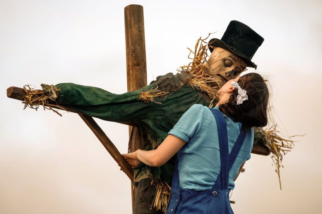 Pearl (Mia Goth) cozying up to a scarecrow.