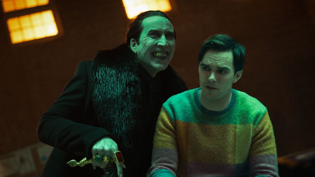 Dracula (Nicolas Cage) grinning broadly next to an intimidated Renfield (Nicholas Hoult). 