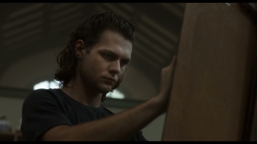 Dalton Lambert (Ty Simpkins) drawing with an intense expression.