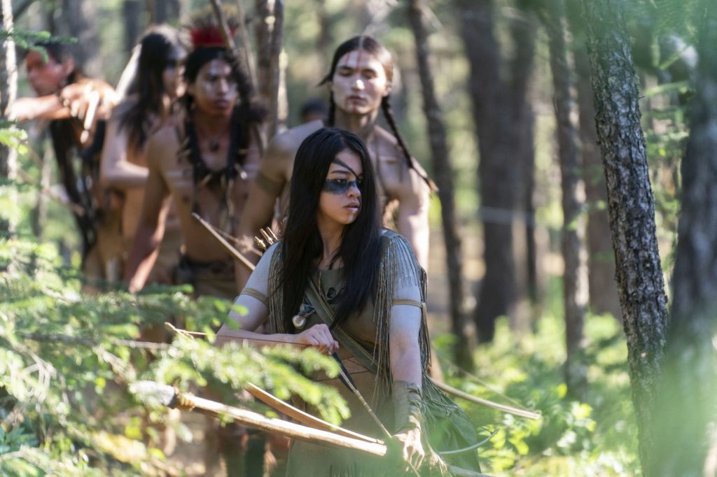 Naru (Amber Midthunder) stalking through the forest with her brother Taabe (Dakota Beavers) and some other warriors.