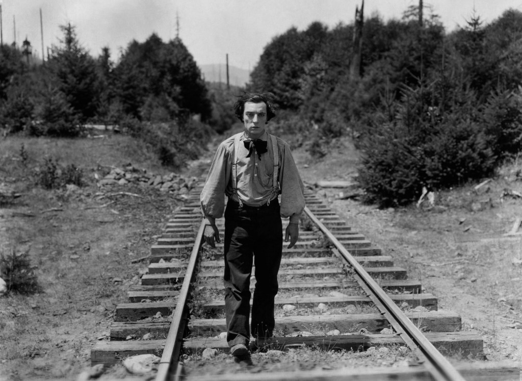 Johnnie (Buster Keaton) walking along the train tracks.